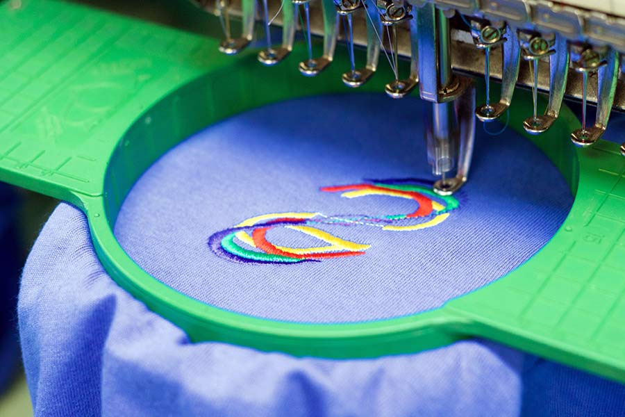 Corporate logo embroidered on dark uniform fabric
